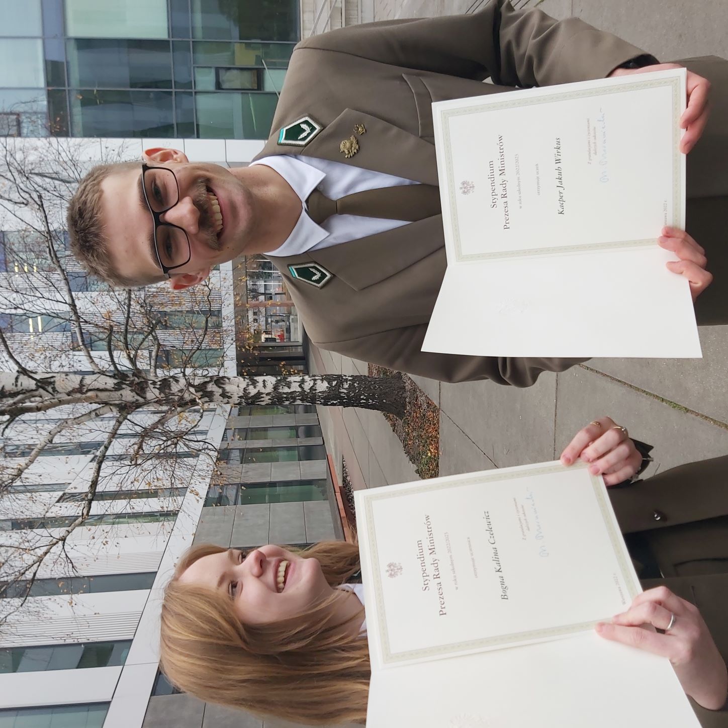Dwoje uczniów - Bogna i Kacper - trzyma w rękach dyplomy potwierdzające otrzymanie Stypendium Prezesa Rady Ministrów